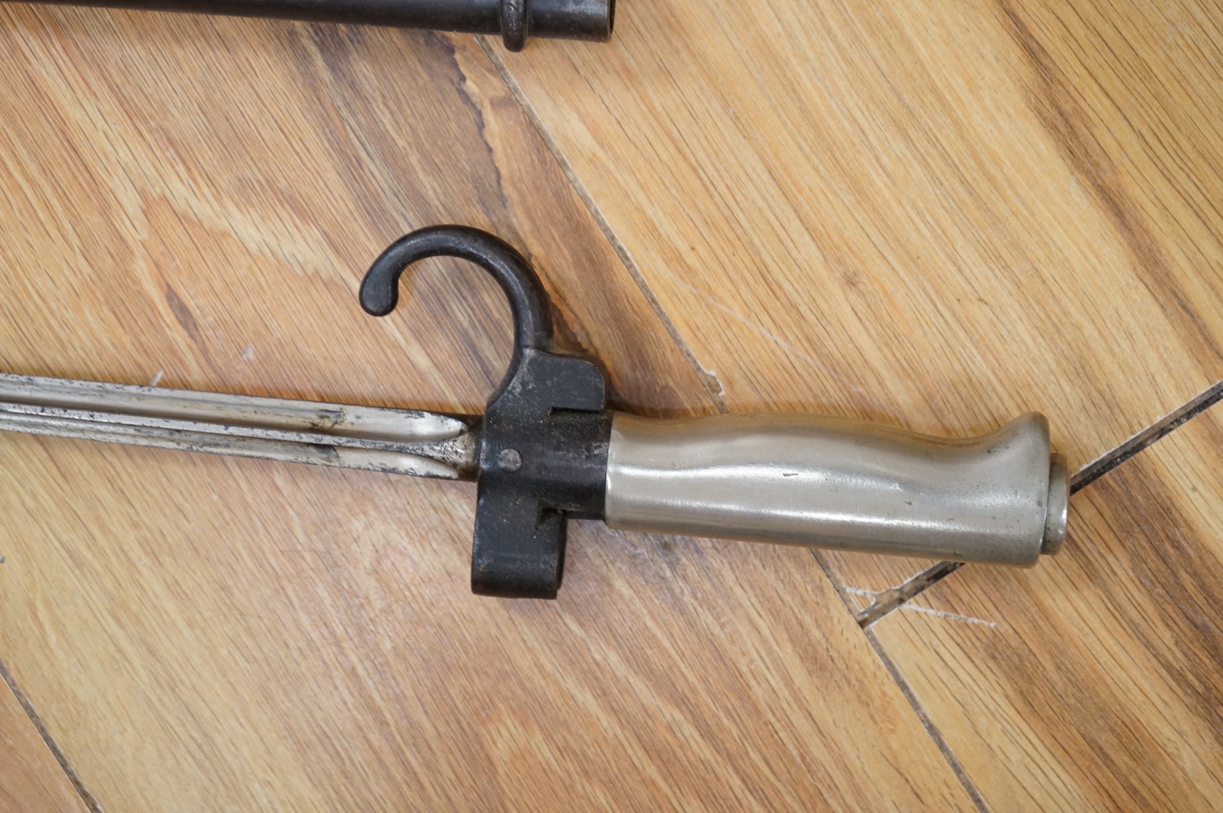Three bayonets; a gras bayonet, a Lebel bayonet and an Indian Enfield style triangular socket bayonet, all in the original scabbards